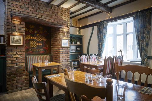a restaurant with tables and chairs and a brick wall at The Ingram Arms in Laughton