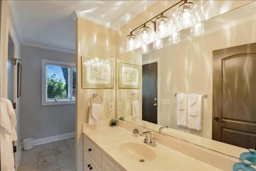 a bathroom with a sink and a large mirror at Woodlawn in Jekyll Island
