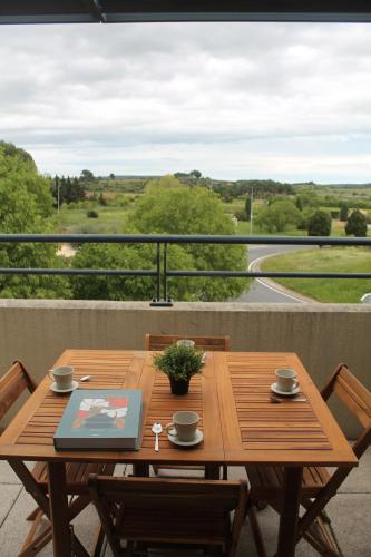 d'une table en bois sur un balcon avec vue. dans l'établissement Logement lumineux près de la mer et de la ville, à Cournonsec