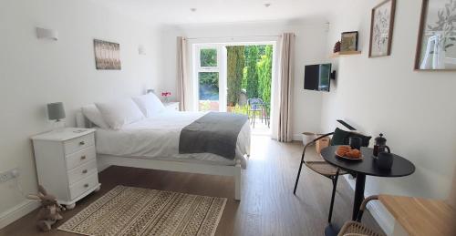 a bedroom with a bed and a table and a window at Cosy Hutch in Saxelby