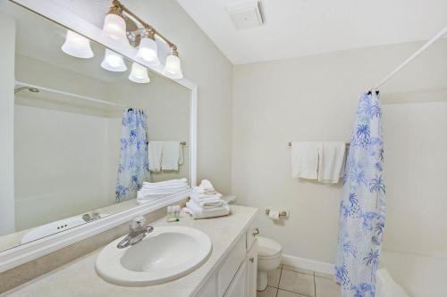 a bathroom with a sink and a toilet and a mirror at Villa 229 in Jekyll Island