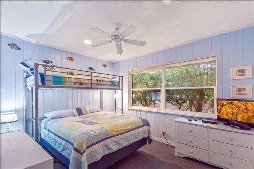 um quarto com uma cama e um ventilador de teto em Sea Watch em Jekyll Island