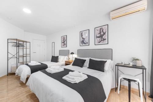 a bedroom with two beds with towels on them at Pensión Plaza América in Alicante