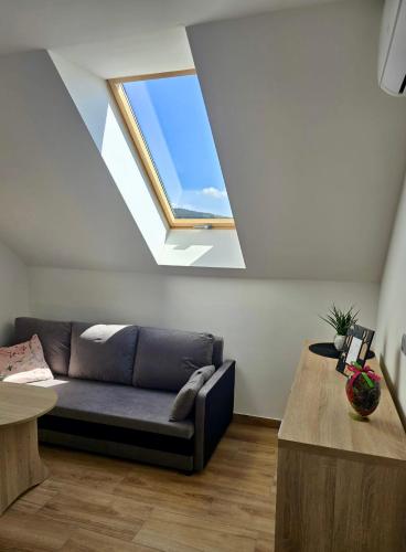 a living room with a couch and a window at Widokówka Kudłacze Domek z Jacuzzi in Pcim
