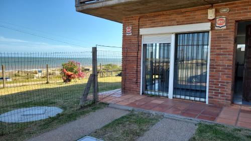 a brick building with a gate and a fence at Duplex Poseidon in Las Toscas