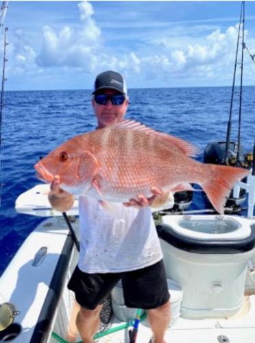a man holding a large fish on a boat at Haven in Port Charlotte in Port Charlotte