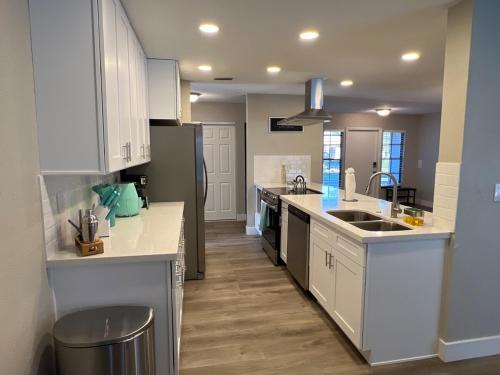 a large kitchen with white cabinets and a sink at Haven in Port Charlotte in Port Charlotte