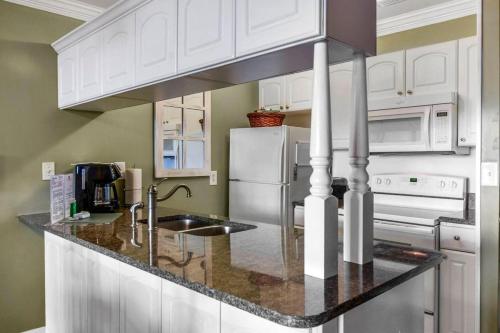 a kitchen with white cabinets and a counter top at Villa 377 Turtle Villa in Jekyll Island