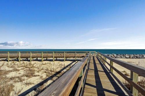 a wooden boardwalk to the beach with a flock of birds at Villa 377 Turtle Villa in Jekyll Island