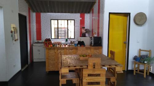 a kitchen with a wooden table and a yellow door at Hospedaje Granja Agroturística Fruto de los Andes Nemocón in Nemocón