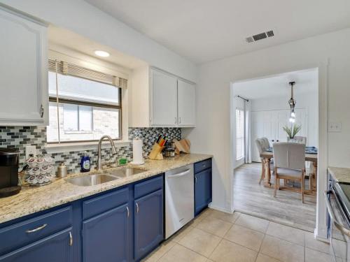 a kitchen with blue cabinets and a dining room at Plano House close to Mckinney and Oak Point Park in Plano