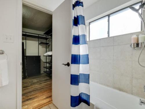a bathroom with a blue and white shower curtain at Plano House close to Mckinney and Oak Point Park in Plano