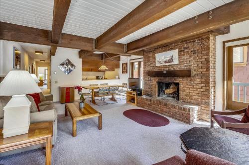 a living room with a fireplace and a brick wall at Iconic Ski Town Charm - Unbeatable Location in Aspen