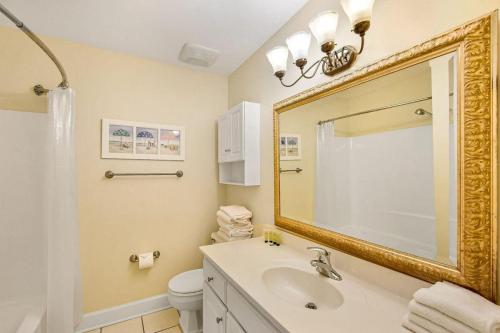 a bathroom with a sink and a mirror and a toilet at Villa 435 in Jekyll Island