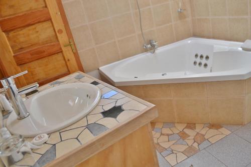 a bathroom with a sink and a bath tub at Hotel Kimal in San Pedro de Atacama