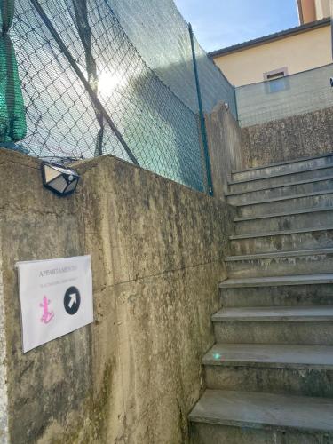 a set of stairs with a sign on a fence at La casa del Geko rosa in Lucca