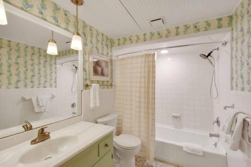 a bathroom with a sink and a toilet and a tub at Sandpiper Hideaway in Jekyll Island