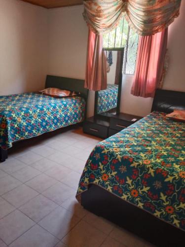 a hotel room with two beds and a mirror at APARTAMENTO 3 HABITACIONES 6 PERSO AIRE ACONDI - EXCELENTE UBI - MINIMO 3 NOCHES - Abonar una noche por adelantado para confirmar reserva in Valledupar