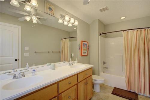 a bathroom with a sink and a toilet and a mirror at Spectacular Sunrise in Jekyll Island