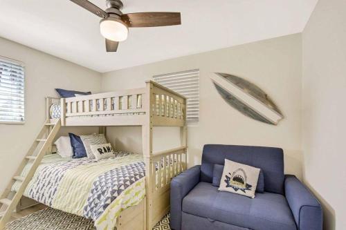 a bedroom with a bunk bed and a blue chair at Spring Cottage in Jekyll Island