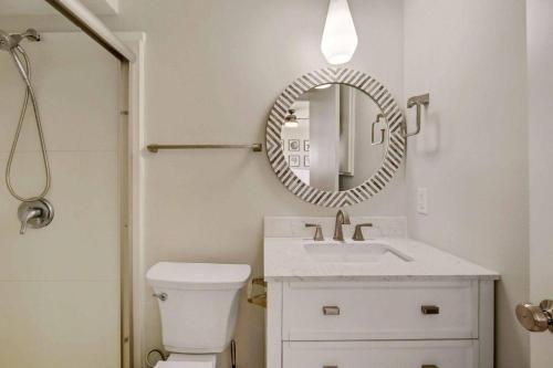 a bathroom with a white toilet and a mirror at Spring Cottage in Jekyll Island