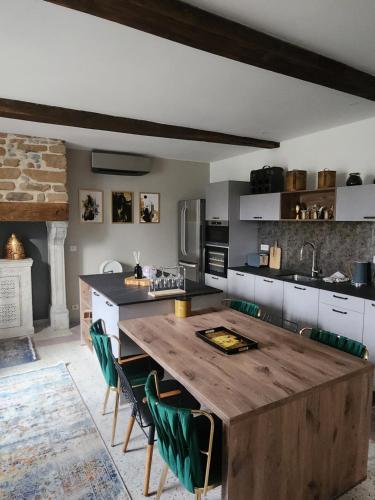 a kitchen with a large wooden table and green chairs at La Casa Mora Grande in Asson