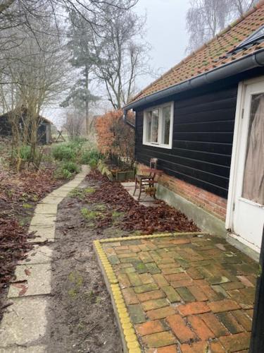 a house with a brick path next to a house at Boerderijtje in Eppenhuizen