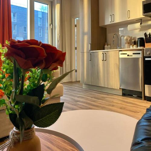 a kitchen with a vase with a red rose on a table at Terracotta 1-BD in Downtown MTL in Montréal
