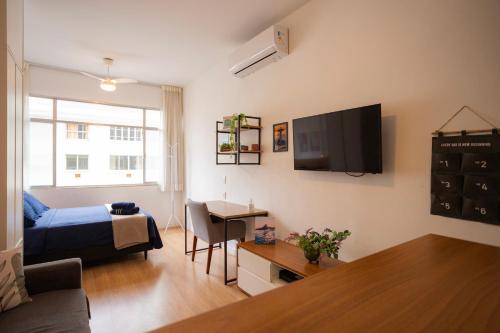 a living room with a couch and a tv on the wall at SUH Copacabana 43 New Confort in Rio de Janeiro
