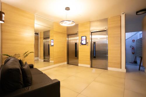 a lobby with a couch and a elevator at SUH Copacabana 43 New Confort in Rio de Janeiro