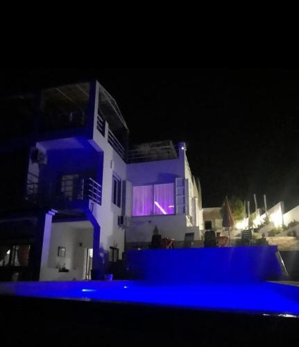 a house with blue lights in front of it at night at Blue ocean villa in Asilah