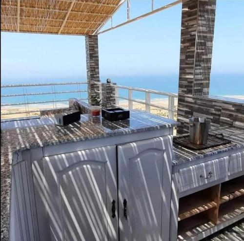 a grill on a balcony with a view of the ocean at Blue ocean villa in Asilah