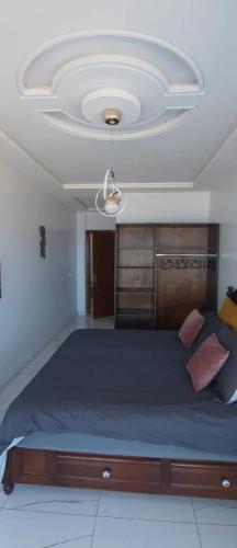 a bedroom with a large bed with a ceiling at Blue ocean villa in Asilah
