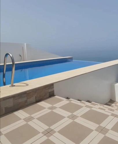 a bathroom with a sink and a tile floor at Blue ocean villa in Asilah