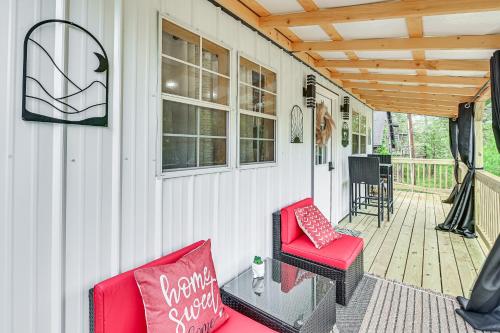 a porch with a red chair and a wooden ceiling at Hot Tub, Fire Pit Lake-View Catlettsburg Getaway! in Catlettsburg