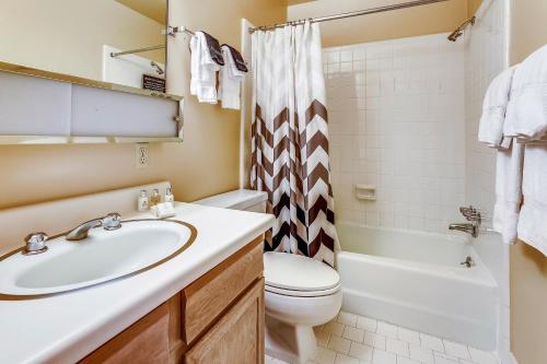 a bathroom with a sink and a toilet at Riverside Condo, with a Pool & Hot Tub - Steps to Town in Aspen