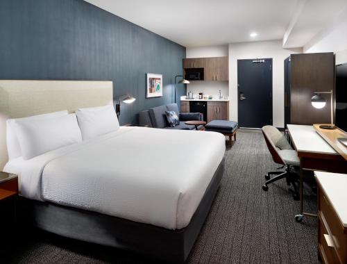 a hotel room with a large bed and a desk at Courtyard by Marriott Atlanta Dunwoody in Atlanta