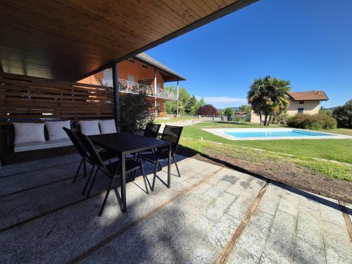 a patio with a table and chairs and a pool at A casa di Elena in Lesa