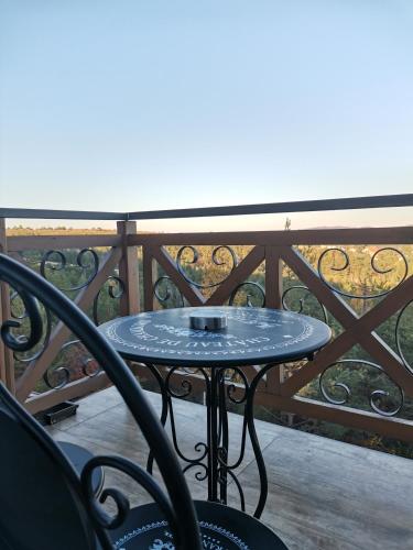 a table on a balcony with a view of the ocean at KATUN Apartmani & SPA in Divčibare