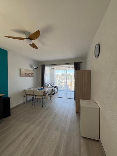 - un salon avec une table et un ventilateur de plafond dans l'établissement Résidence Aigue Marine Front de Mer, au Cap d'Agde