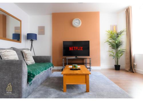 a living room with a couch and a tv at Stay Central - 2BR Apartment Near Beach & City Highlights in Minehead