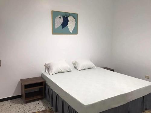 - un lit dans une chambre avec une photo sur le mur dans l'établissement رزق هاوس, à Ash Shūnah ash Shamālīyah