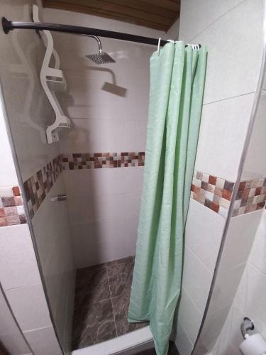 a shower with a green shower curtain in a bathroom at Apartamento Hogar Caribeño 2H con AA in Santa Marta