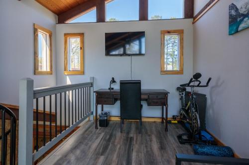 an office with a desk and a bike in a room at Hot Tub and Mini Golf Mtn-View Haven in Kodak! in Kodak
