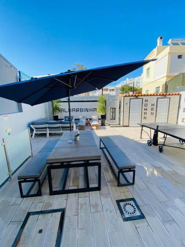 a patio with a picnic table and an umbrella at AL Barbinha in Faro