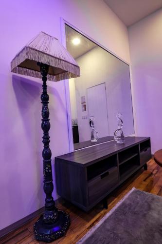 a bathroom with a mirror and a table with a lamp at Hotel Emma in Mexico City