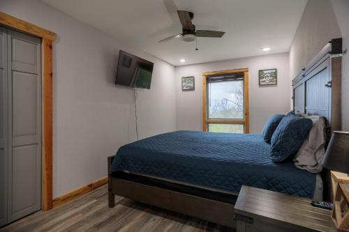a bedroom with a blue bed and a window at Hot Tub and Mini Golf Mtn-View Haven in Kodak! in Kodak