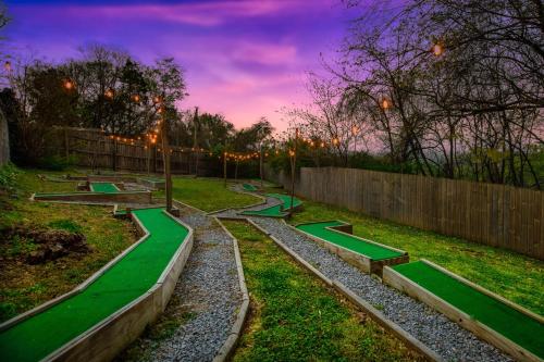 a garden with green benches and a fence at sunset at Hot Tub and Mini Golf Mtn-View Haven in Kodak! in Kodak