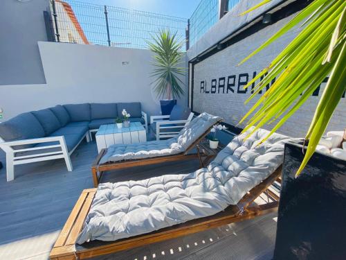 a patio with lounge chairs and a couch on a building at AL Barbinha in Faro