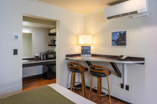 a hotel room with a desk and two stools at Earthbox Inn & Spa in Friday Harbor
